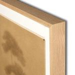 Close-up of white oak frame corner with visible wood grain and texture around the painting edge