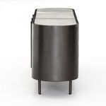 Side view focusing on smooth rounded arm of metal body and elevated black legs