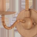 Close-up of the rattan wrapped curved arm and rounded base with natural wood finish