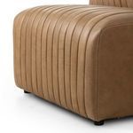 Close-up of bottom side corner with curved armrest and visible black rounded feet