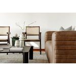 Two Takashi chairs styled in a modern living room with coffee table, vase, and leather sofa