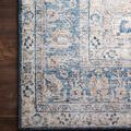 Detailed close-up of Layla rug corner showing floral motifs in blue, tangerine, and cream on hardwood floor