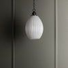 Small old bronze pendant light hanging against dark wall paneling in moody room