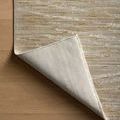 Rug corner flipped over showing woven underside and fringed edge detail