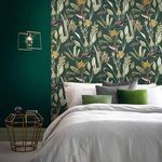 Bedroom wall covered in wallpaper with green background and botanical bird pattern, styled with white bedding and green pi...