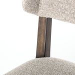 Close-up joint where backrest wood frame meets seat upholstery fabric on Jax Dining Chair