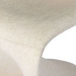 Close-up detail of curved seat edge and stitching in cream linen upholstery