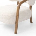 Low angle close-up of side oak leg and fluffy seat upholstery edges