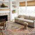 Sorrento rug styled in a bright living room under furniture with natural light and woven window shades