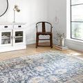 Teagan Denim Pebble Rug shown in bright white room with wooden chair and sideboard highlighting muted blue shade variation