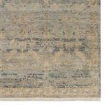 Detailed shot of rug section showing complex border pattern in muted beige and purple tones