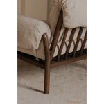Close rear detail of wood spindle back and angled leg with ruched arm fabric