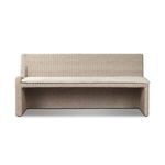 Vintage white outdoor dining banquette with woven rattan texture and a soft beige fabric seat cushion