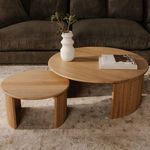 Round oak coffee table styled with a small matching side table and white vase with green leaves