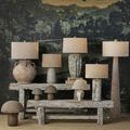 Pompeii Table Lamp in room setting with rustic wood shelves and varied lamps for scale