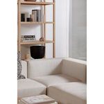 Black decorative vessel on a shelf behind a light beige sectional sofa in living room
