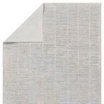 Top corner of the rug flipped to show solid light gray backing material