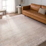 Palermo rug styled in a modern living room with tan leather sofa, cream side table, and soft natural light