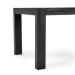 Angle close-up on the sturdy, square table leg and apron with black wood grain texture