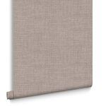 Rolled wallpaper with visible hanging edge curling slightly away from wall
