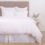 Blake White/Natural duvet with subtle interwoven stripe texture, displayed on bed with matching shams and white bed skirt