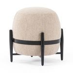 Round Sia Ottoman in beige bouclé fabric with black wooden legs and band around middle