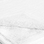 Close-up showing the fluffy sherpa backing folded over textured linen blend surface of the throw blanket