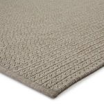 Close-up of rug corner showing thick braided texture and finished fabric edge