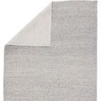 Top right corner of rug folded to reveal light ivory woven backing