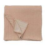Folded Vancouver Coverlet with one corner flipped revealing contrasting light beige underside