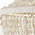 Close-up of natural shell strands hanging from white twine wrapped ring on the chandelier