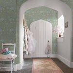 Wildflower wallpaper applied to hallway walls with white arched door and soft natural light