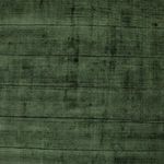 Detailed view of rich green rug surface highlighting soft hand-carved linear texture
