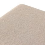 Fabric texture close-up revealing subtle pattern and fiber detail on ottoman upholstery