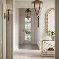 Lyndall Wall Sconce mounted in hallway featuring off-white walls and decorative mirror on side