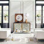 Waterfall Coffee Table shown styled in living room setting between two white upholstered armchairs on patterned rug