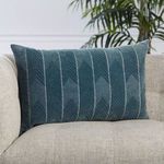 Lumbar pillow styled on beige textured sofa with green plant in background