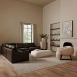 Full sectional showcased in minimalist living room with fireplace and contemporary chair