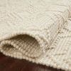 Partially rolled ivory rug on wood floor showing thickness and raised knot texture pattern