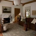 Milena Sage Ivory Rug styled in a living room setting with brown sofa, white lamp, and wooden accents.