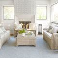 Birdie denim rug styled in bright living room with wicker furniture and white fireplace