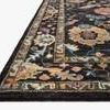 Rug shown at a low angle highlighting thick pile, edges, and multicolor floral design with wool texture