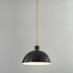 Glossy black pendant light hanging against light gray wall with pendant switched on, glowing white interior