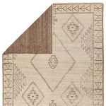 Rug flipped to show dark taupe wool backing with faint geometric pattern
