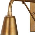 Detail view of brushed brass finish and metal texture on sconce’s curved arm and upper fixture