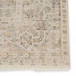Zoomed detail of rug border with visible fringe and vintage brocade pattern