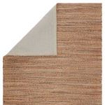 Cotton backed underside of solid tan rug variant shown with corner folded over