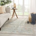 Living room scene with teal armchair and wooden console over Stag Oriental rug, adding cozy styling