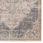 Detailed view of one rug corner highlighting intricate border and faded blue and tan hues