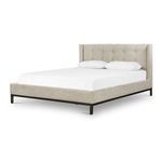 Angled side view of king bed showing tufted headboard, white linens, and gunmetal legs